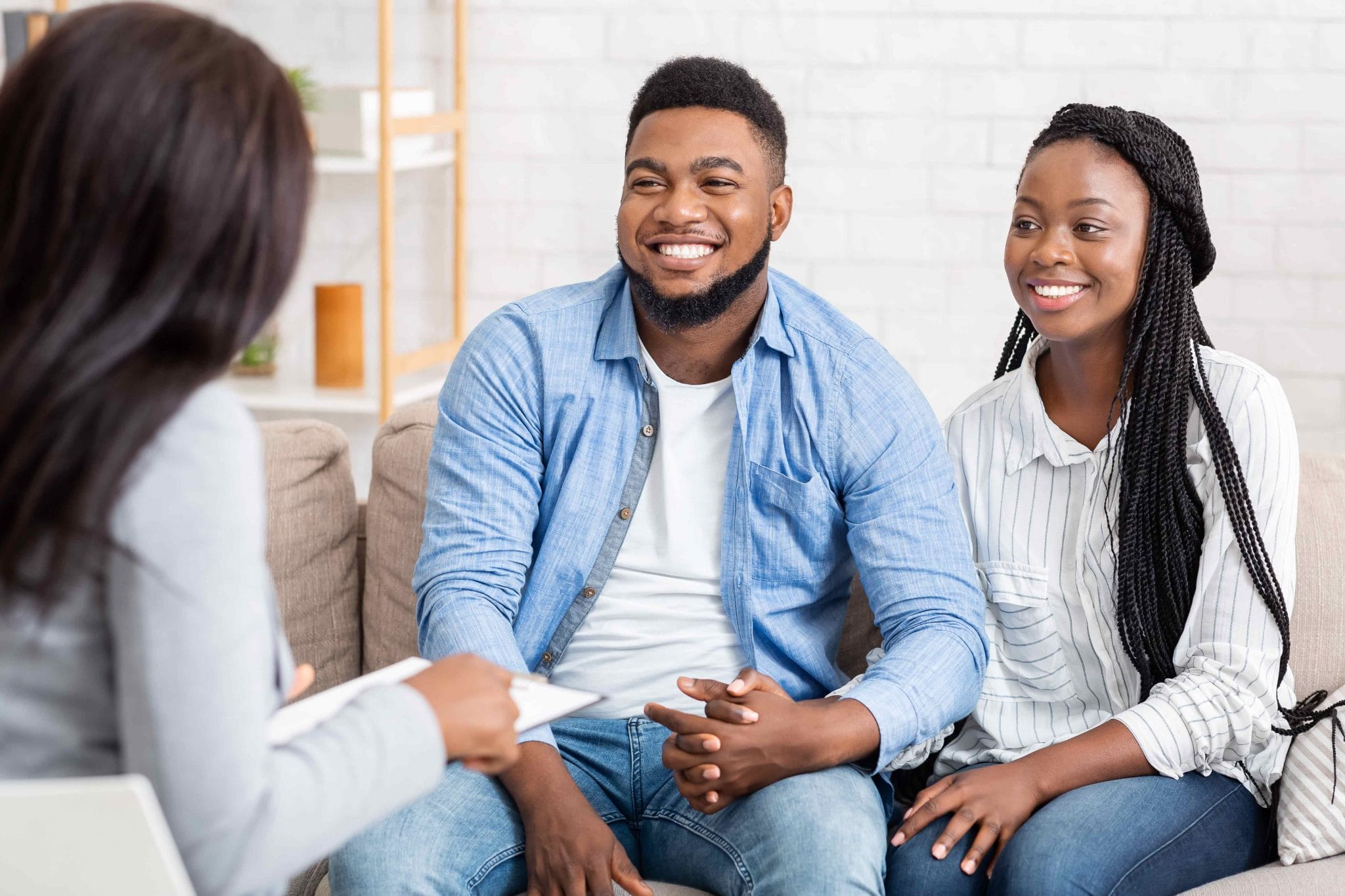 African American couple smiling during counseling session speaking with a therapist