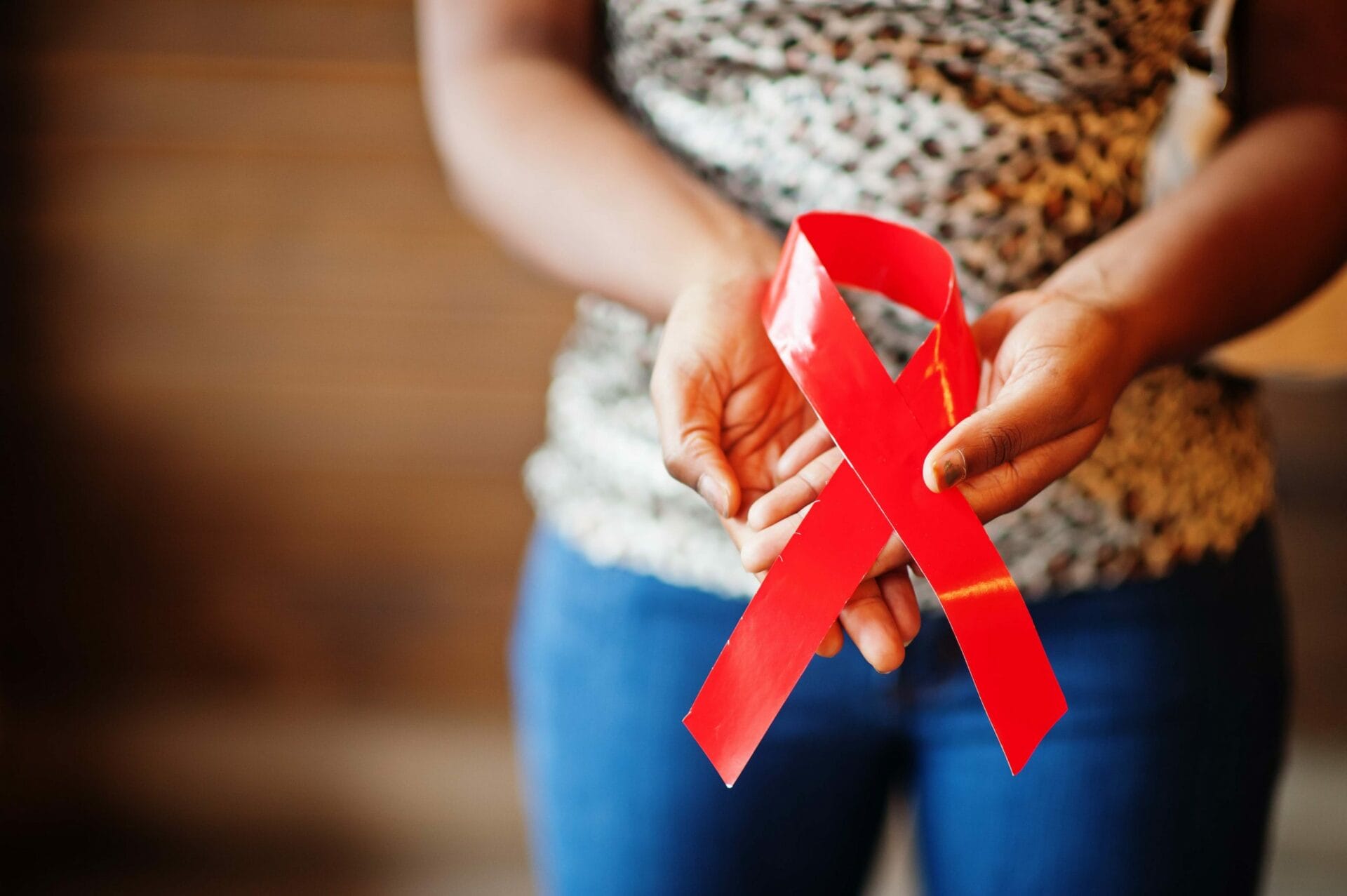 African American Woman holding a HIV awareness ribbon