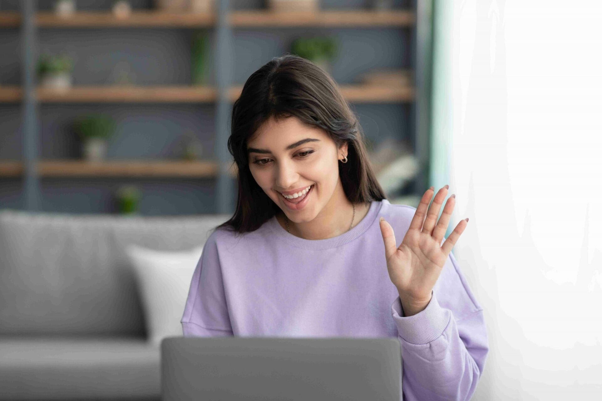 Woman waving during her Telehealth therapy session