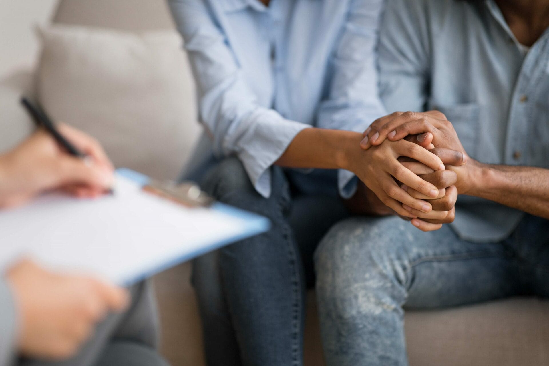 Couple holding hands during counseling session with therapist