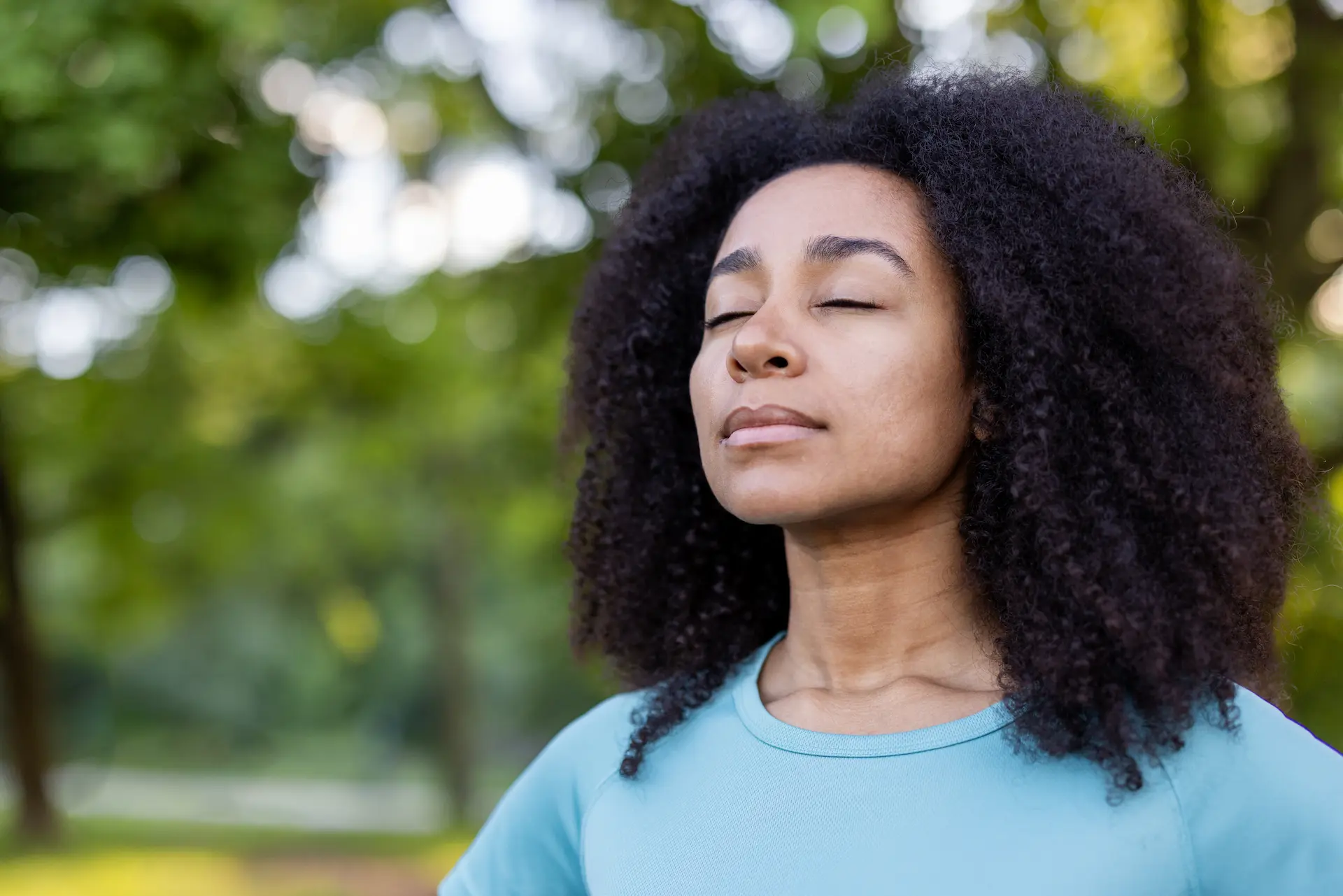 Woman practicing deep breathing outdoors to manage anxiety in daily life