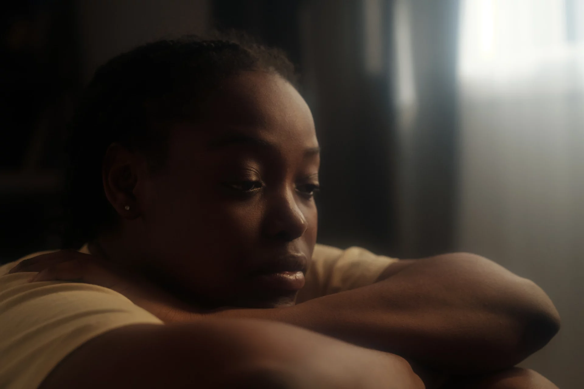 Woman sitting alone indoors reflecting on depression symptoms versus a bad week